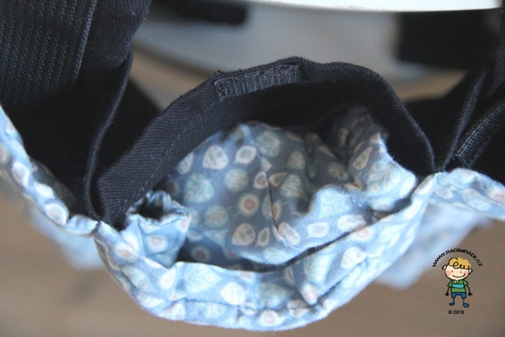 Nosítko KiBi: Detail na kapsičku na zádech, do které se schová kapucka.